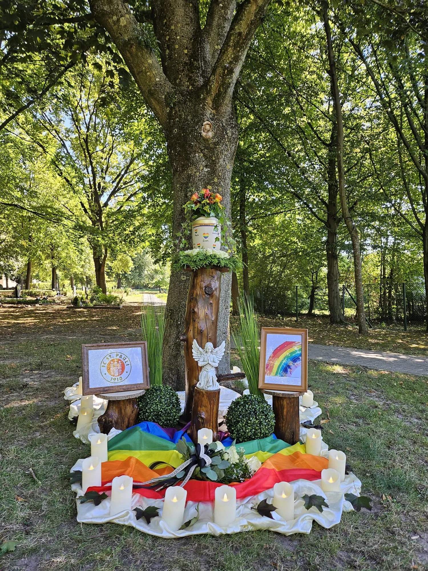 Naturbestattung: würdevoll geschmückte Urne an einem Baum im Wald