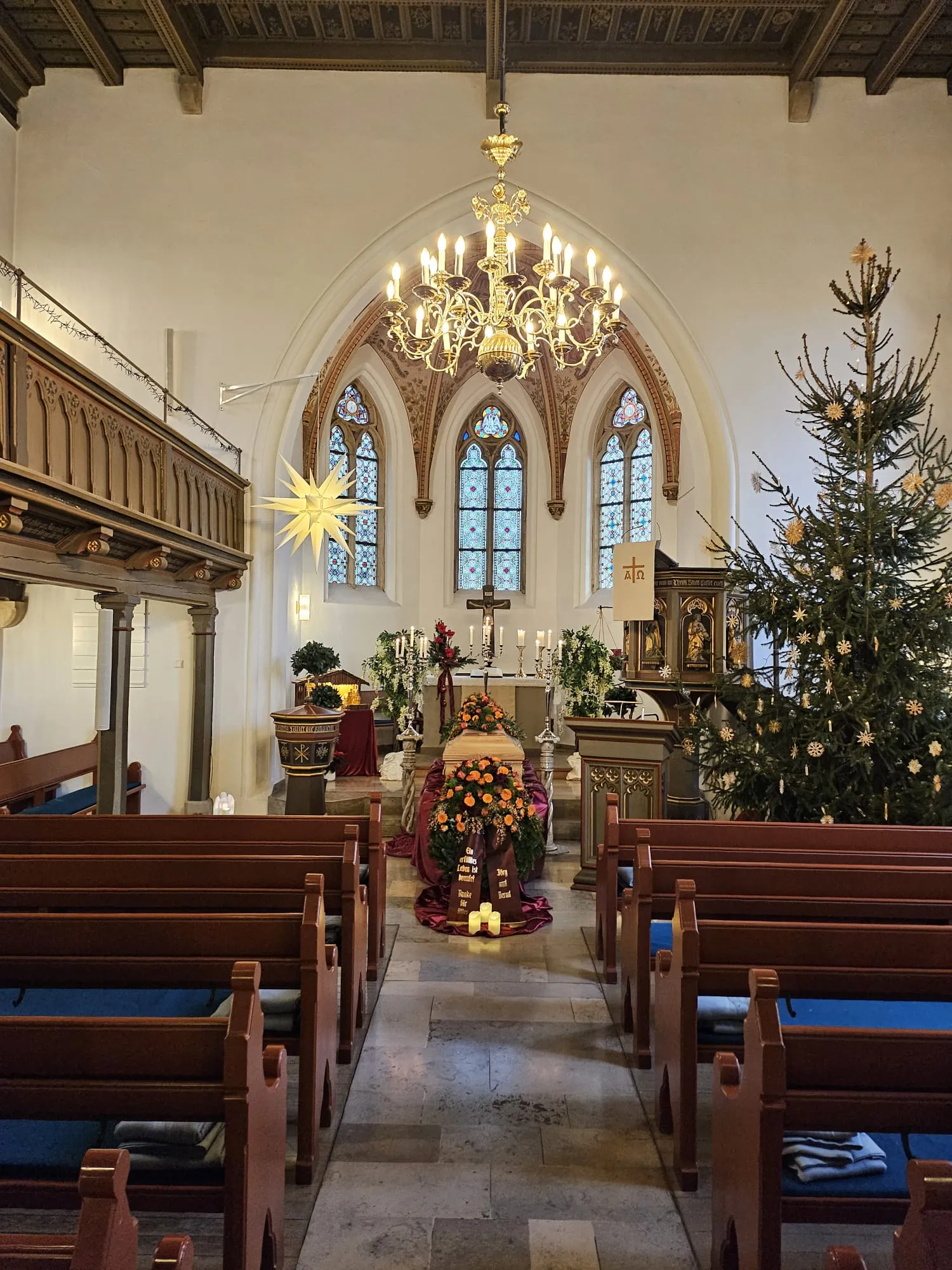 Feierlich geschmückte Kirche mit Sarg und Blumenschmuck zur Trauerfeier