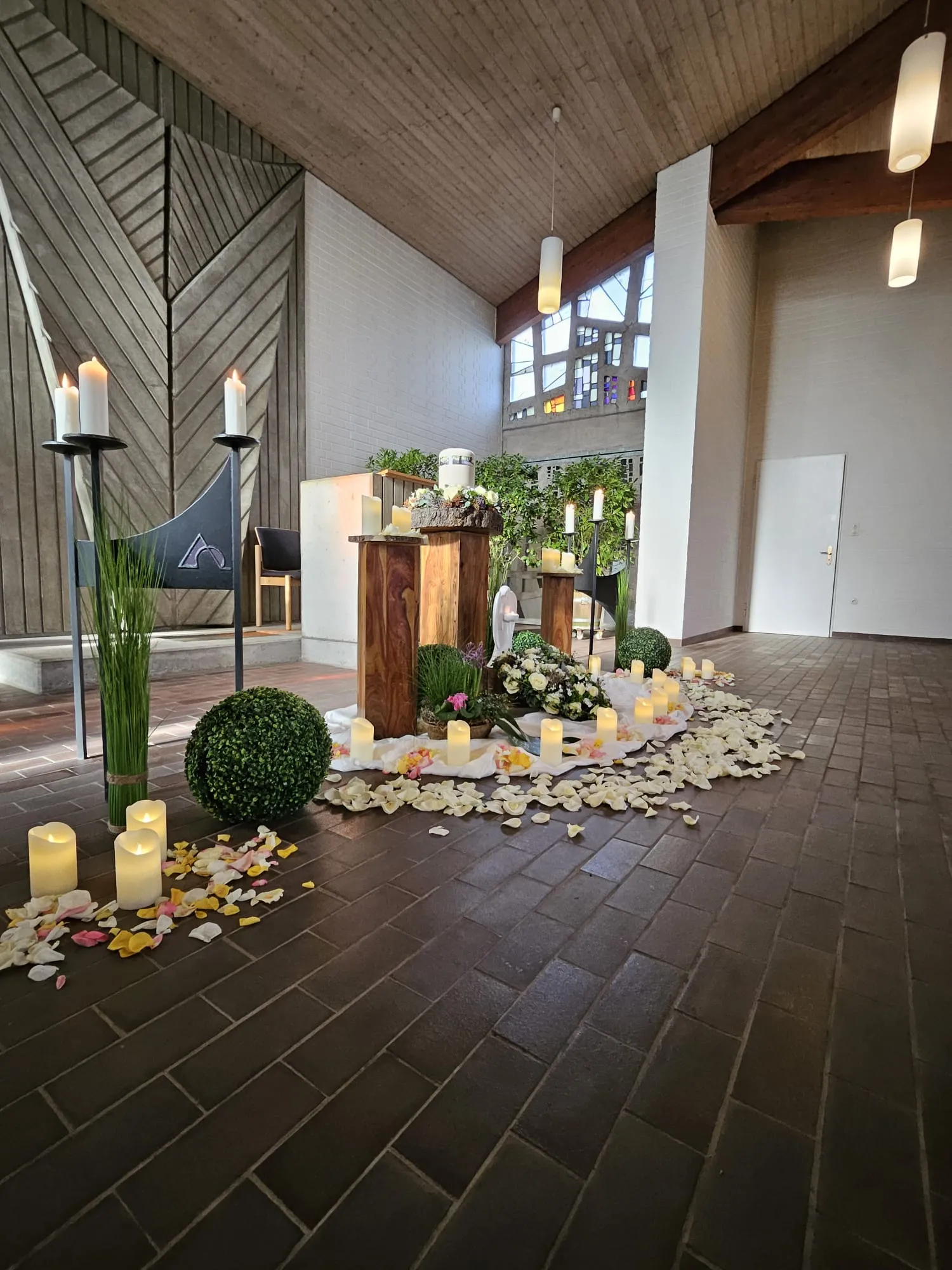 Urne mit Blumenschmuck in heller, moderner Trauerkapelle