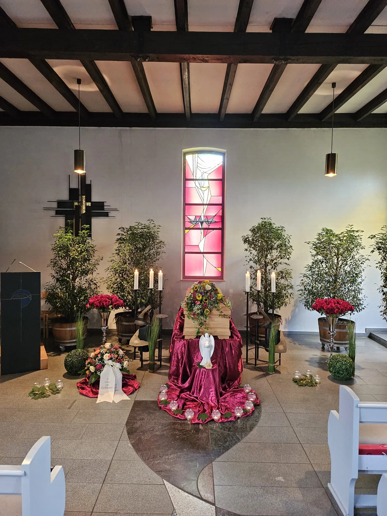 Sarg mit Blumenschmuck und Kerzen in der Trauerkapelle